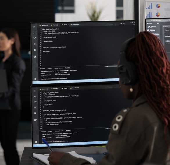 Woman coding with dual displays